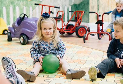 Preschoolers sitting on the floor playing with a ball