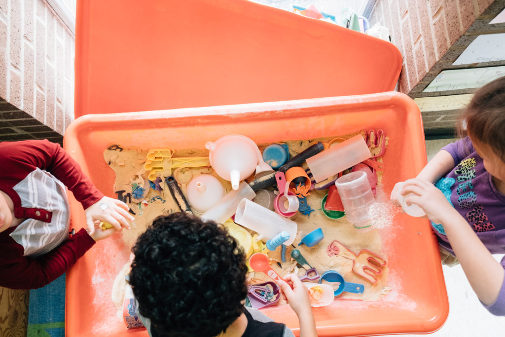 Children playing in sand bin