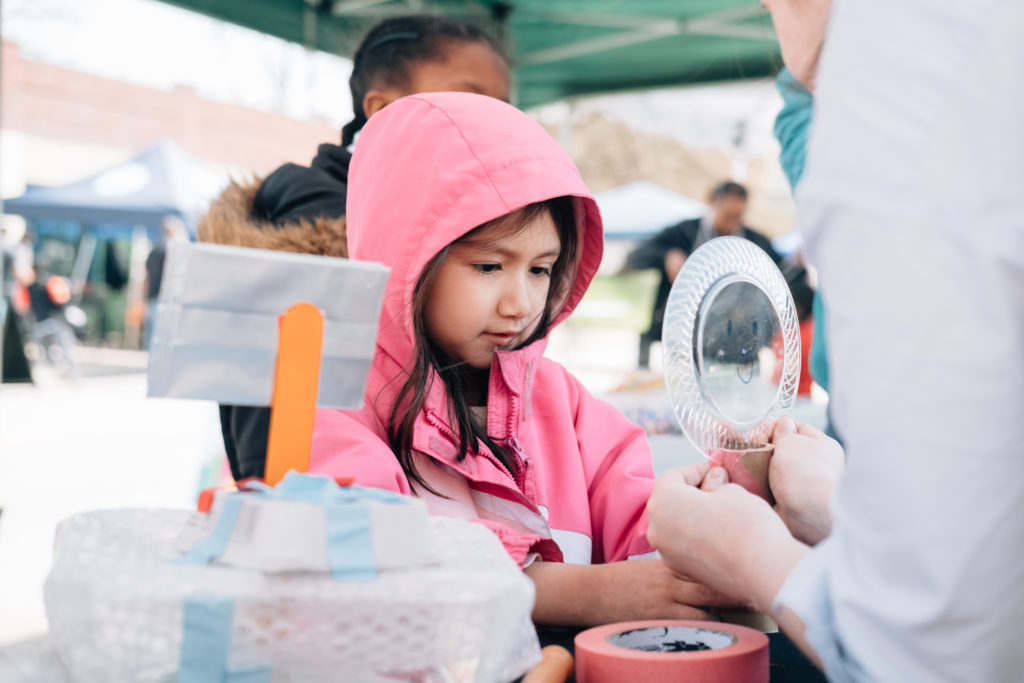 Spanish girl makes craft at block party.
