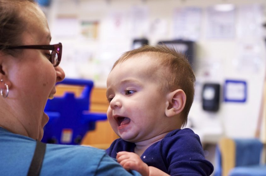 Baby smiling with caregiver