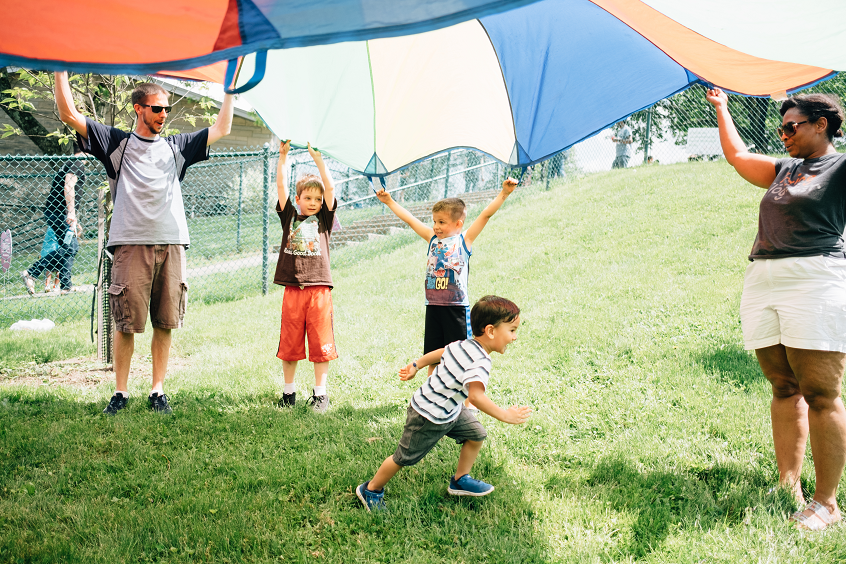 Children playing beneath a parachute