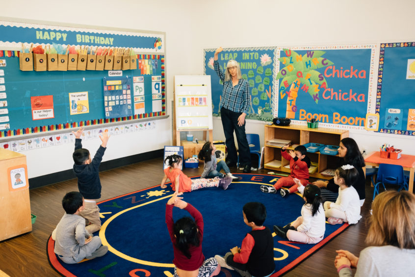 Image: An early learning professional leads circle time with her young learners.