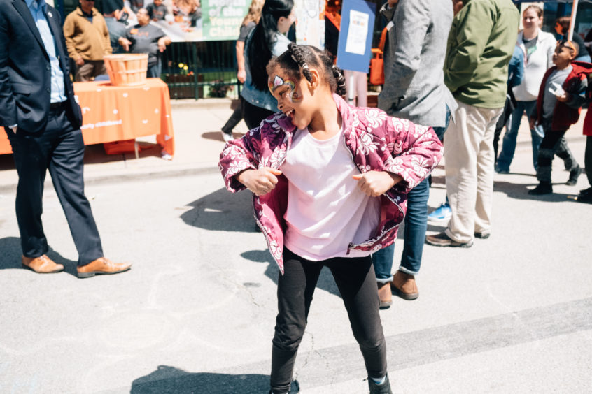 Picture: At the Homewood Block Party, a young child grabs the ends of her coat while dancing happily.