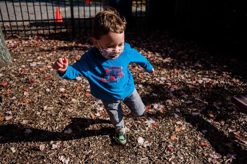 A young boy runs around the playground happily.