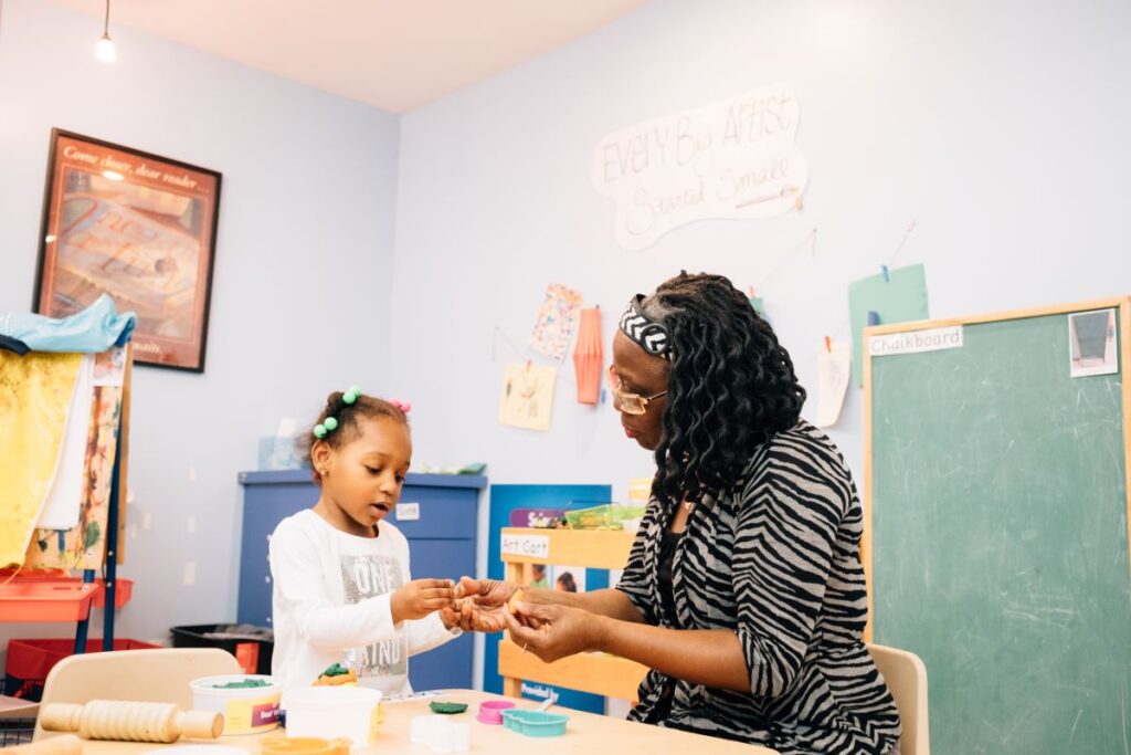 An adult sitting and playing with a child | Family Guide to Discussing Race and Equity with Young Children