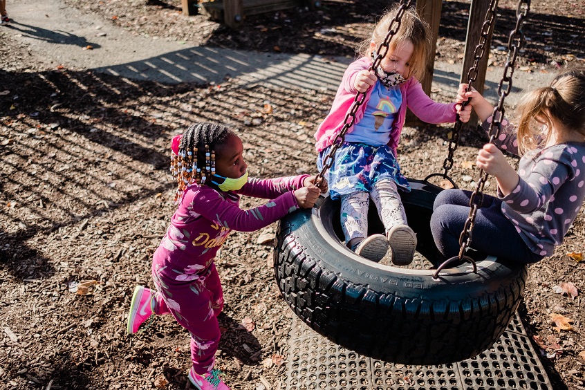 Resource List Information on Raising Anti-Racist Children | Black and white children playing on a tire swing