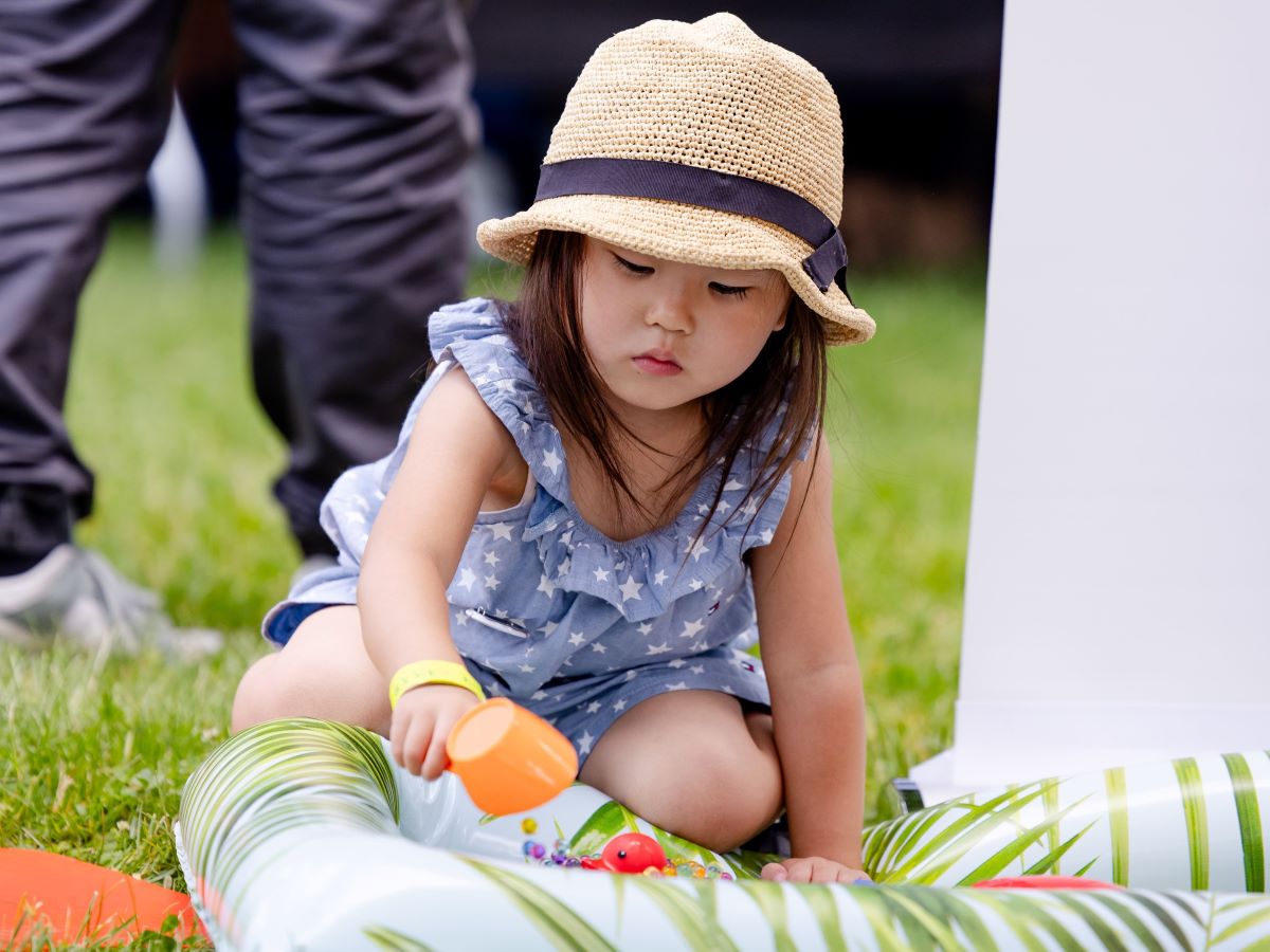 A young girl sitting on her knees playing with an activity in front of here | Brain-Building Activities for Infants, Toddlers, and Children