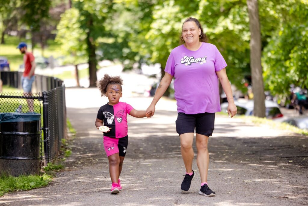 A mom is walking with her child through the park | How Play Aids Adult Executive Function Skills 