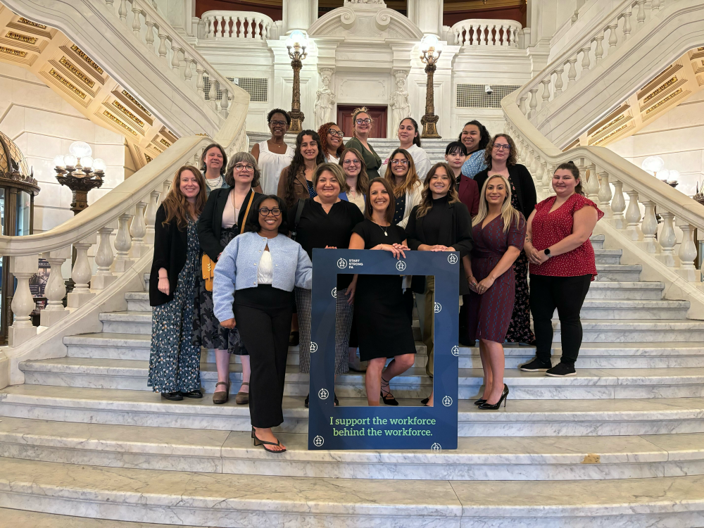 A group of women posing on the grand staircase in the PA State Capitol building